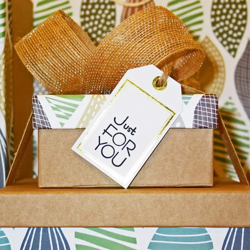 cadeau bébé naissance dans boîte kraft avec ruban doré et étiquette