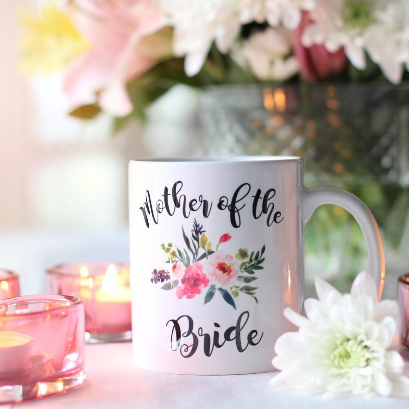 mug personnalisé "mother of the bride" avec fleurs, bougies roses et bouquet en arrière-plan