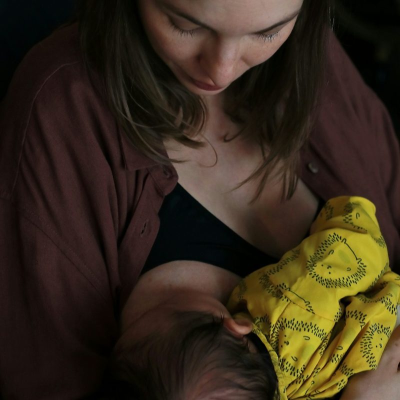 femme allaitant son bébé avec un tissu jaune à motifs