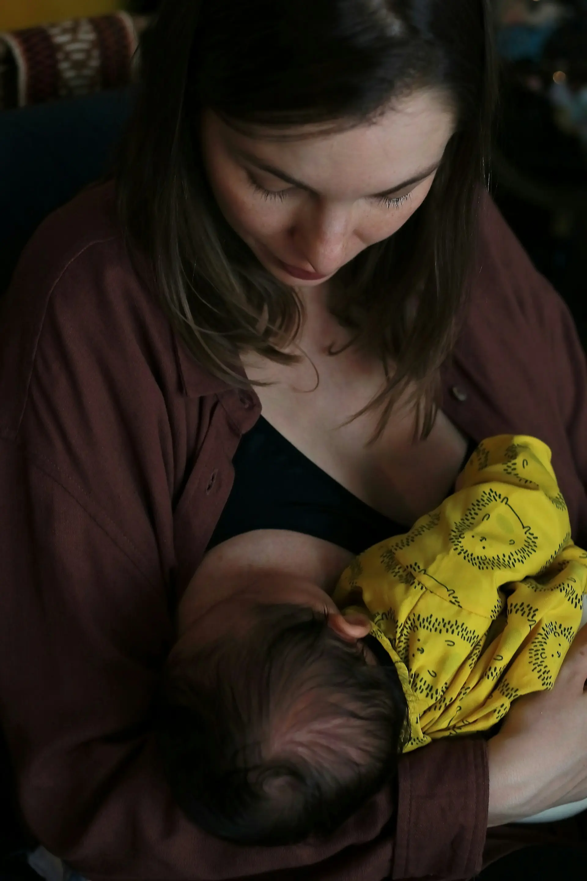 femme allaitant son bébé avec un tissu jaune à motifs