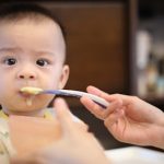 person feeding baby