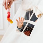 A baby reaches for a colorful toy through a teepee tent window, symbolizing curiosity and play.