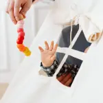 A baby reaches for a colorful toy through a teepee tent window, symbolizing curiosity and play.
