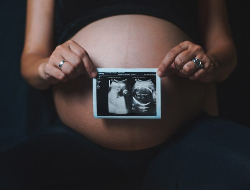 a pregnant woman holding a camera in her hands